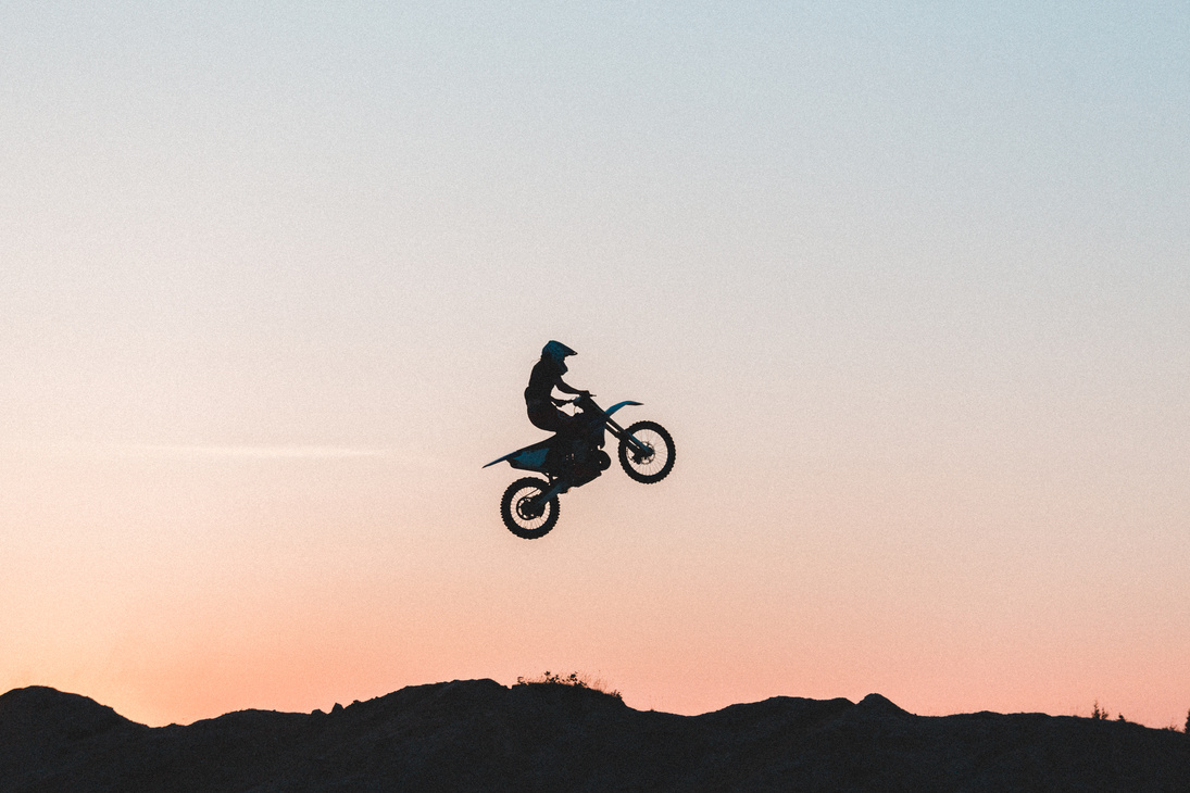 Silhouette of Man Riding Bicycle on Mid Air during Sunset